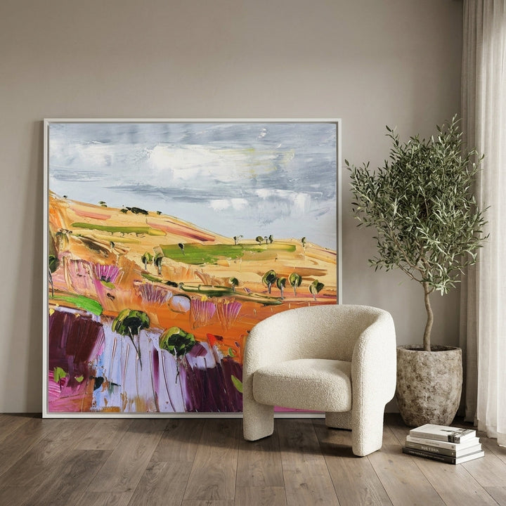 Oversized statement canvas wall art with a white surround leaning against the wall in a luxe dining room