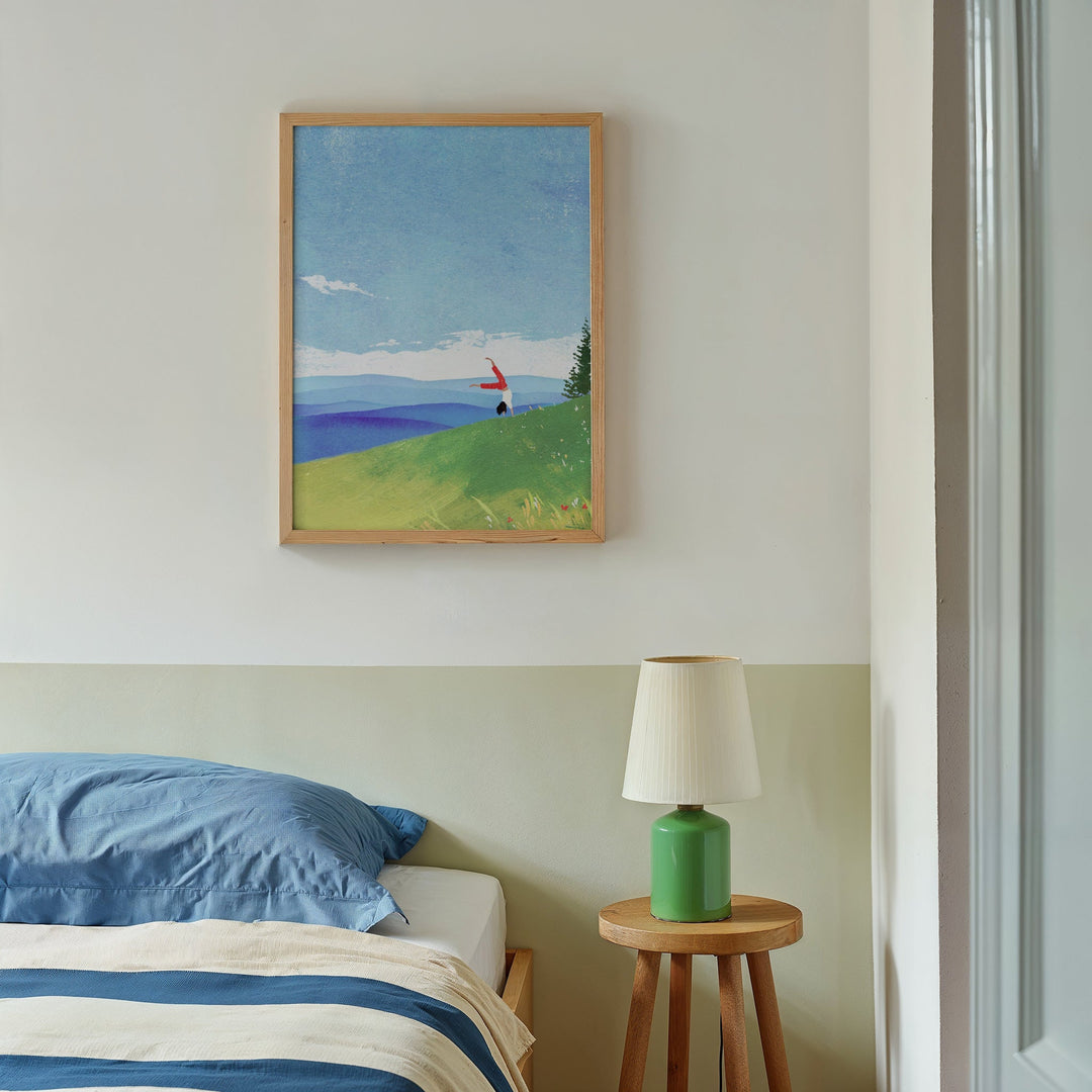 Bed with side table and lamp with artwork hanging on wall