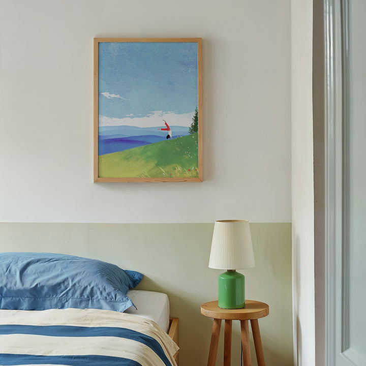 Bed with side table and lamp with artwork hanging on wall