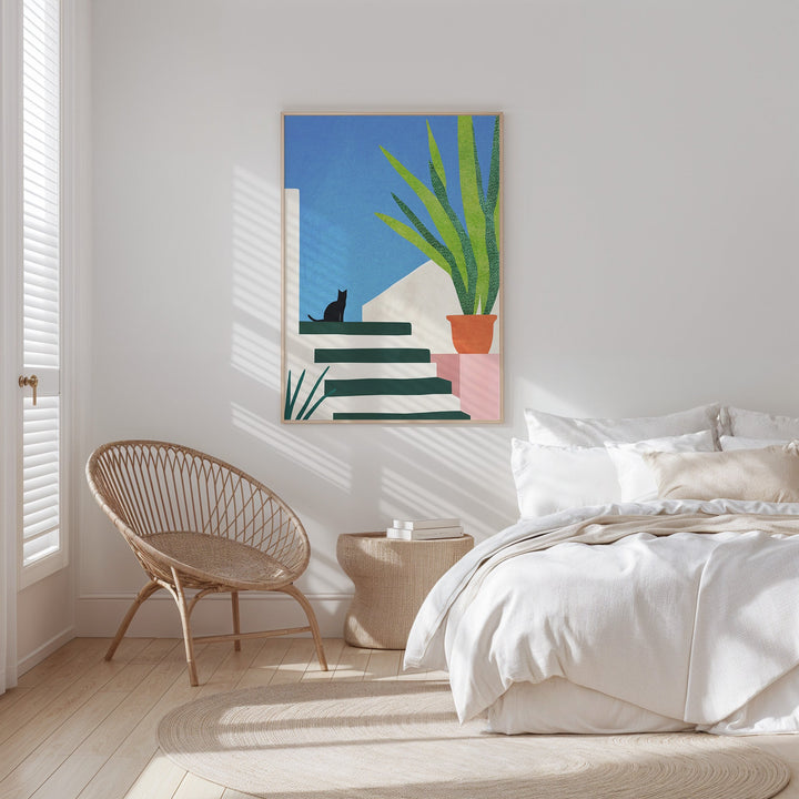 bright bedroom with chair on the side and cat artwork on the wall