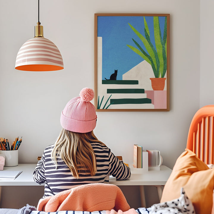 Girl studying in her room with artwork hanged on wall