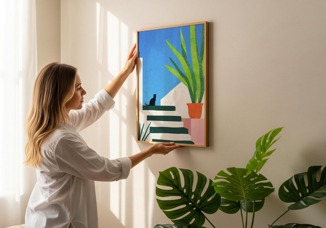 girl holding cat artwork on wall