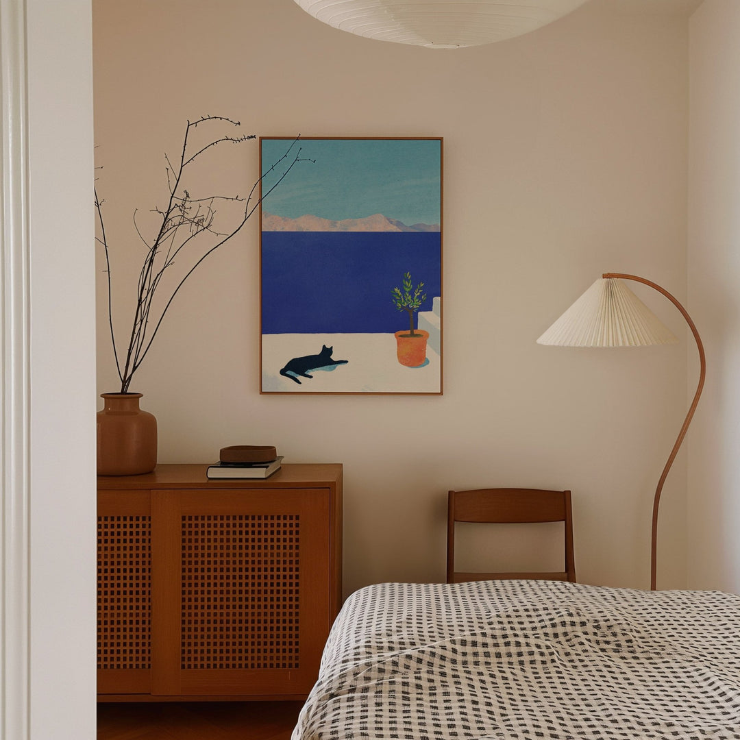 Bedroom with brown cabinet and lamp and artwork hanging on wall