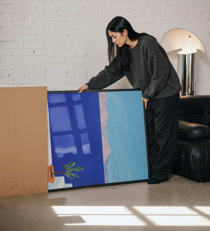 Woman unboxing an artwork in living room.