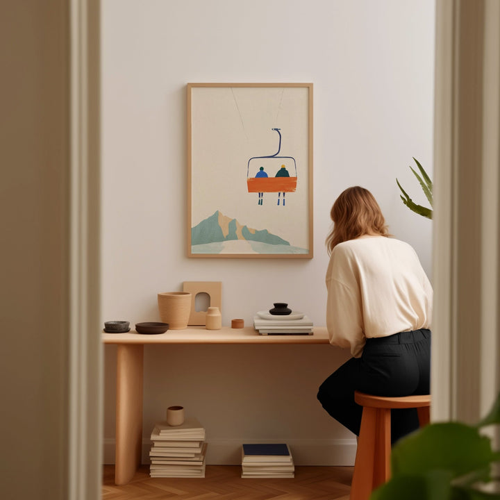 Girls sitting on a wood chair with wooden table and artwork hanging on wall