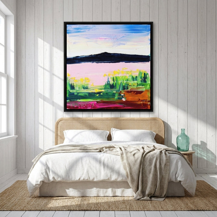 Canvas wall art with a black surround styled on the wall in a coastal bedroom