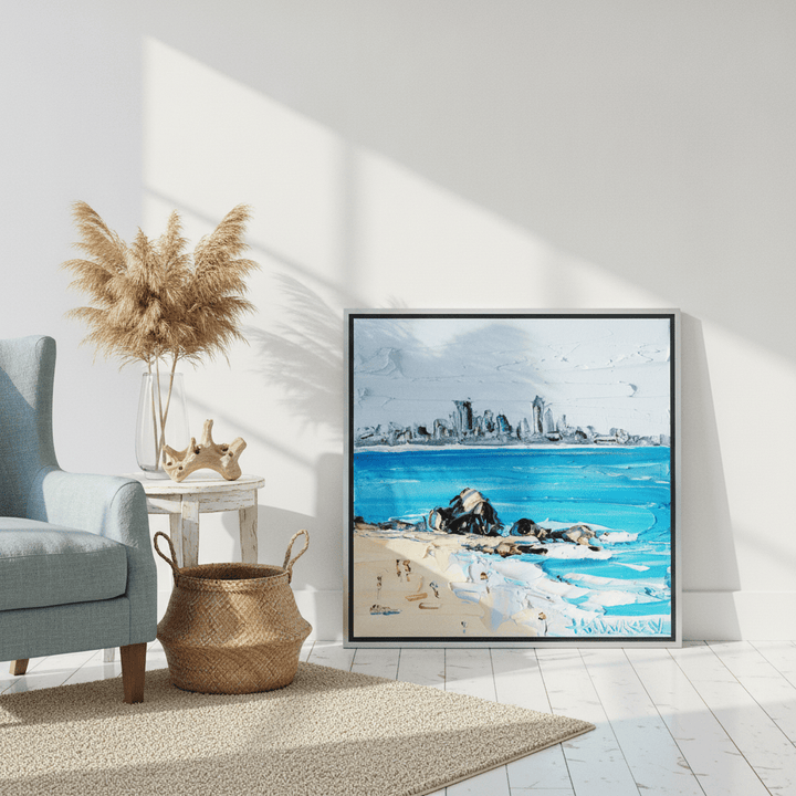 Canvas wall art with a silver leaf surround leaning against the wall in a coastal living room
