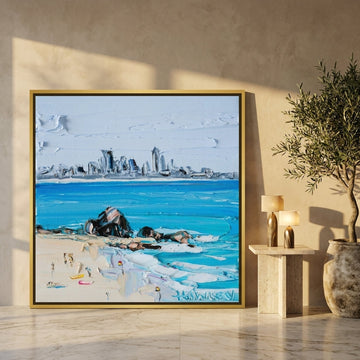 Oversized statement canvas wall art with a gold leaf surround leaning against the wall in a luxe dining room