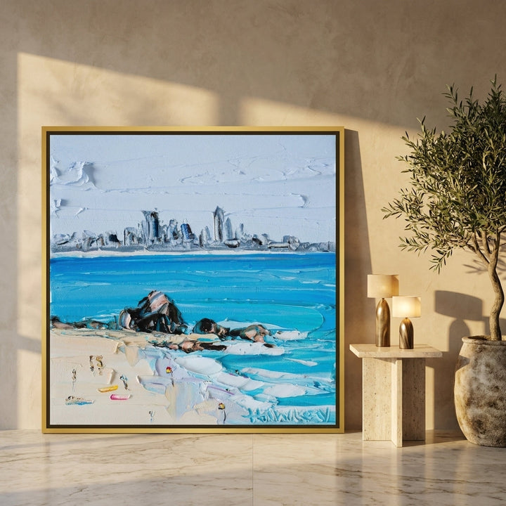 Oversized statement canvas wall art with a gold leaf surround leaning against the wall in a luxe dining room