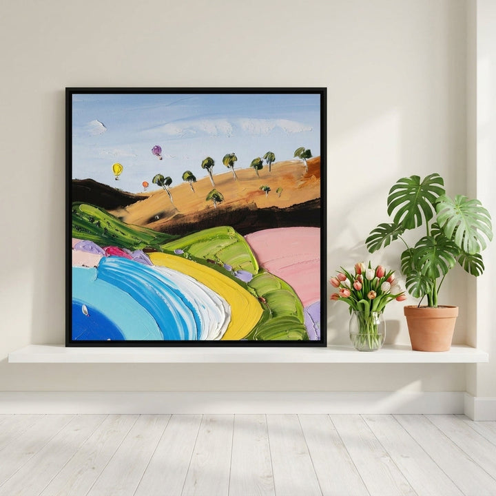 Canvas wall art with a black surround standing on a shelf in a bright Scandinavian home office