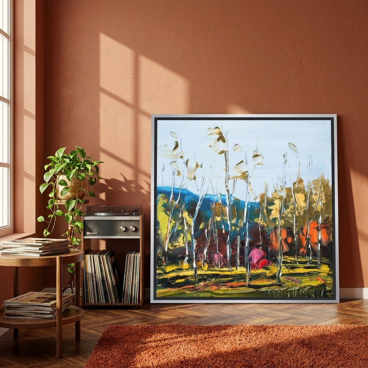 Canvas wall art with a silver leaf surround leaning against the wall in a retro 70s home office