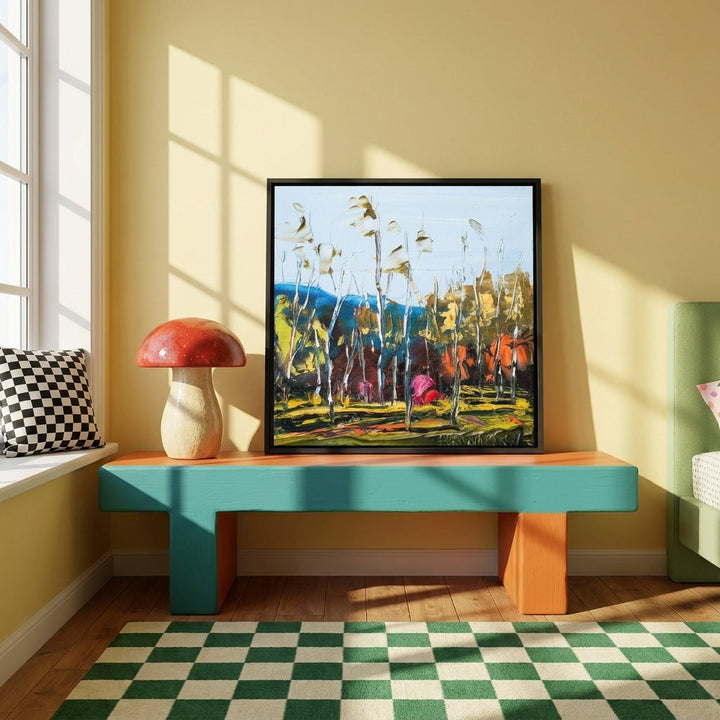 Canvas wall art with a black surround standing on a side table in a colourful eclectic bedroom
