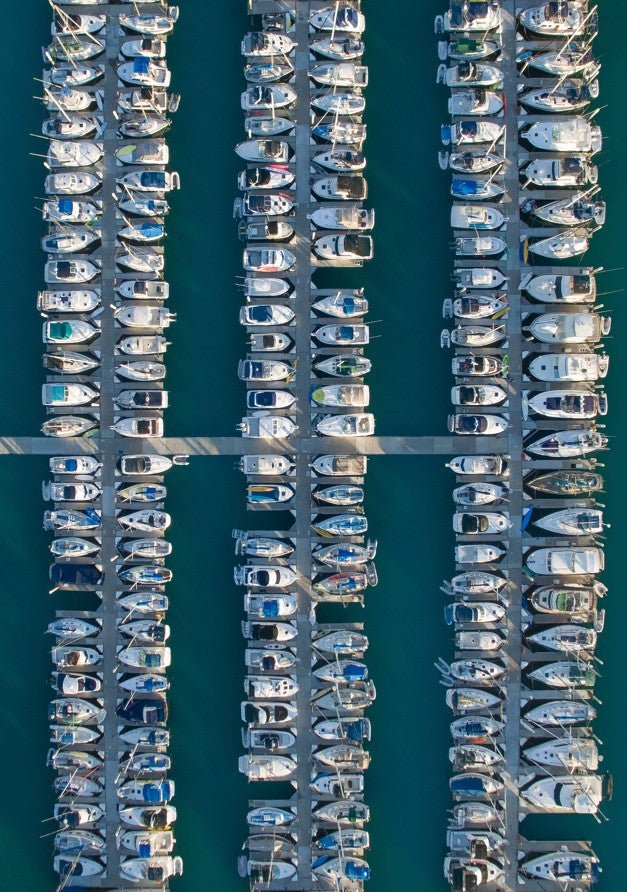 Aerial view of a marina with rows of docked boats. framed