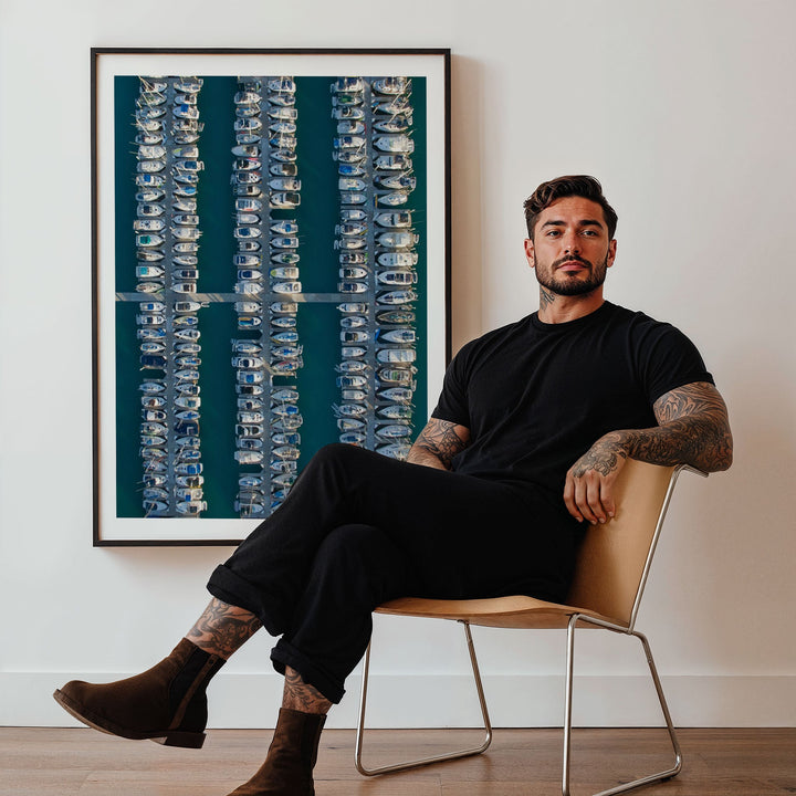 Man sitting on a chair in a room with a large abstract painting on the wall.