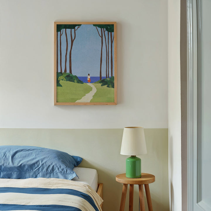 Artwork above a bed with a lamp on a side table.