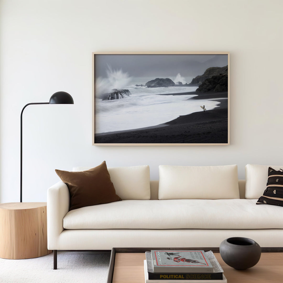 Modern living room with a white sofa, decorative pillows, and a landscape picture on the wall.