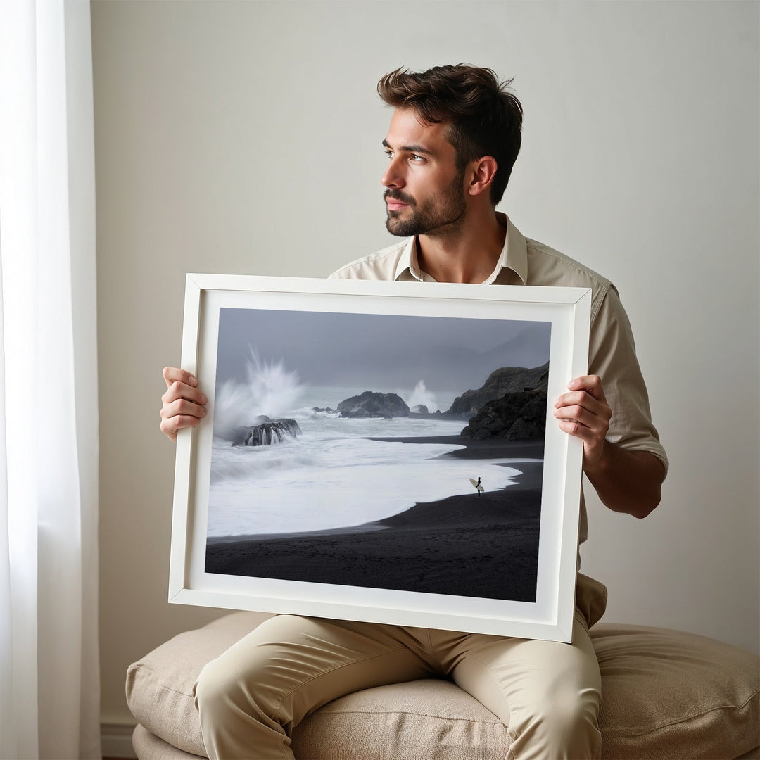 Man holding a photograph of a beach scene