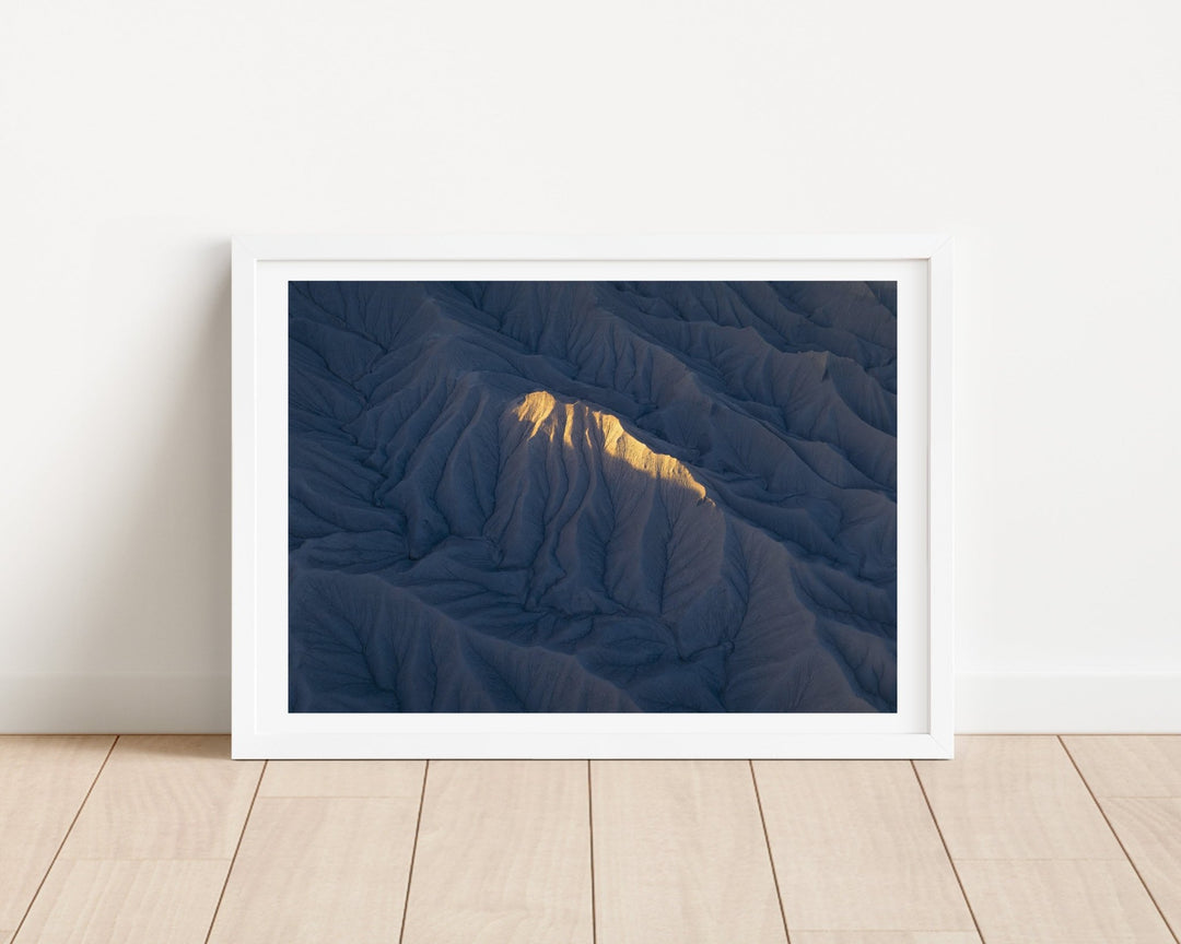 Photograph of a mountain landscape on a light wooden floor.