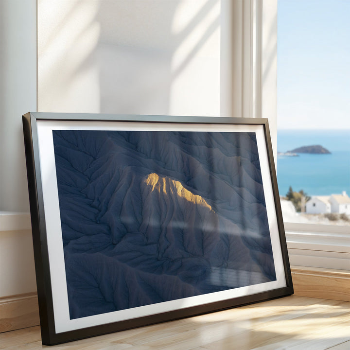 Artwork on a wooden surface with a window view of the ocean.