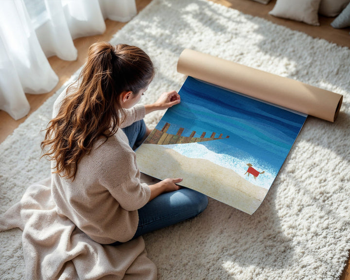 Woman unrolling a large scenic poster on a carpeted floor.