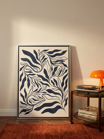 Canvas wall art with a silver leaf surround leaning against the wall in a retro 70s bedroom