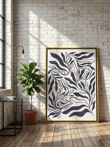 Oversized statement canvas wall art with a gold leaf surround leaning against the wall in an industrial loft living room