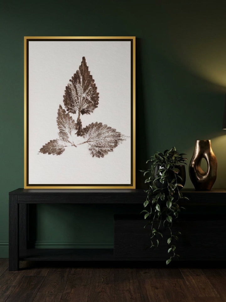 Canvas wall art with a gold leaf surround standing on a console in a moody home office