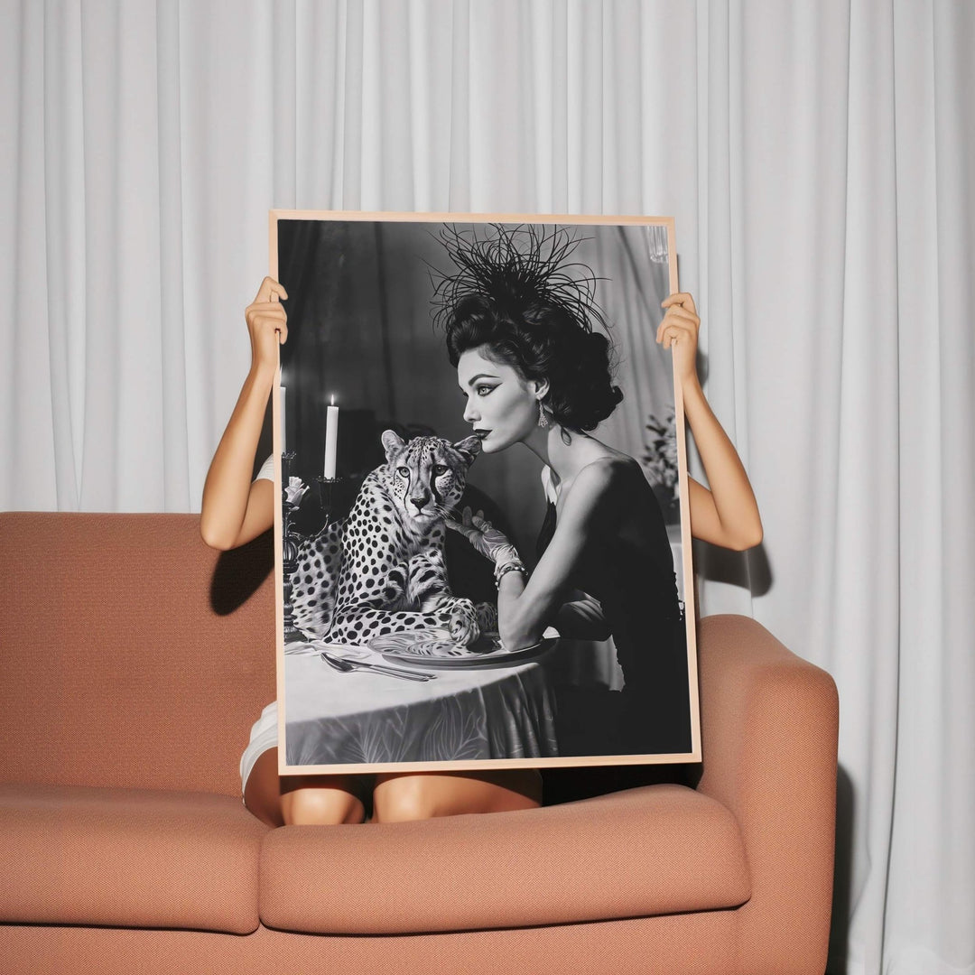 Person holding a black and white photograph of a woman with a leopard on a couch.