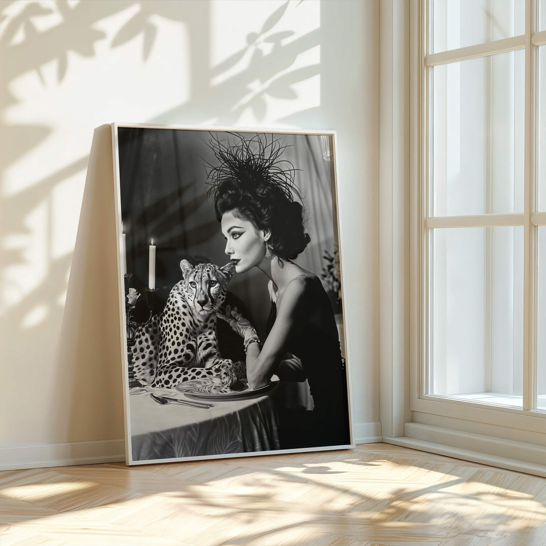 black and white portrait of a woman with a leopard on a table in a sunlit room.