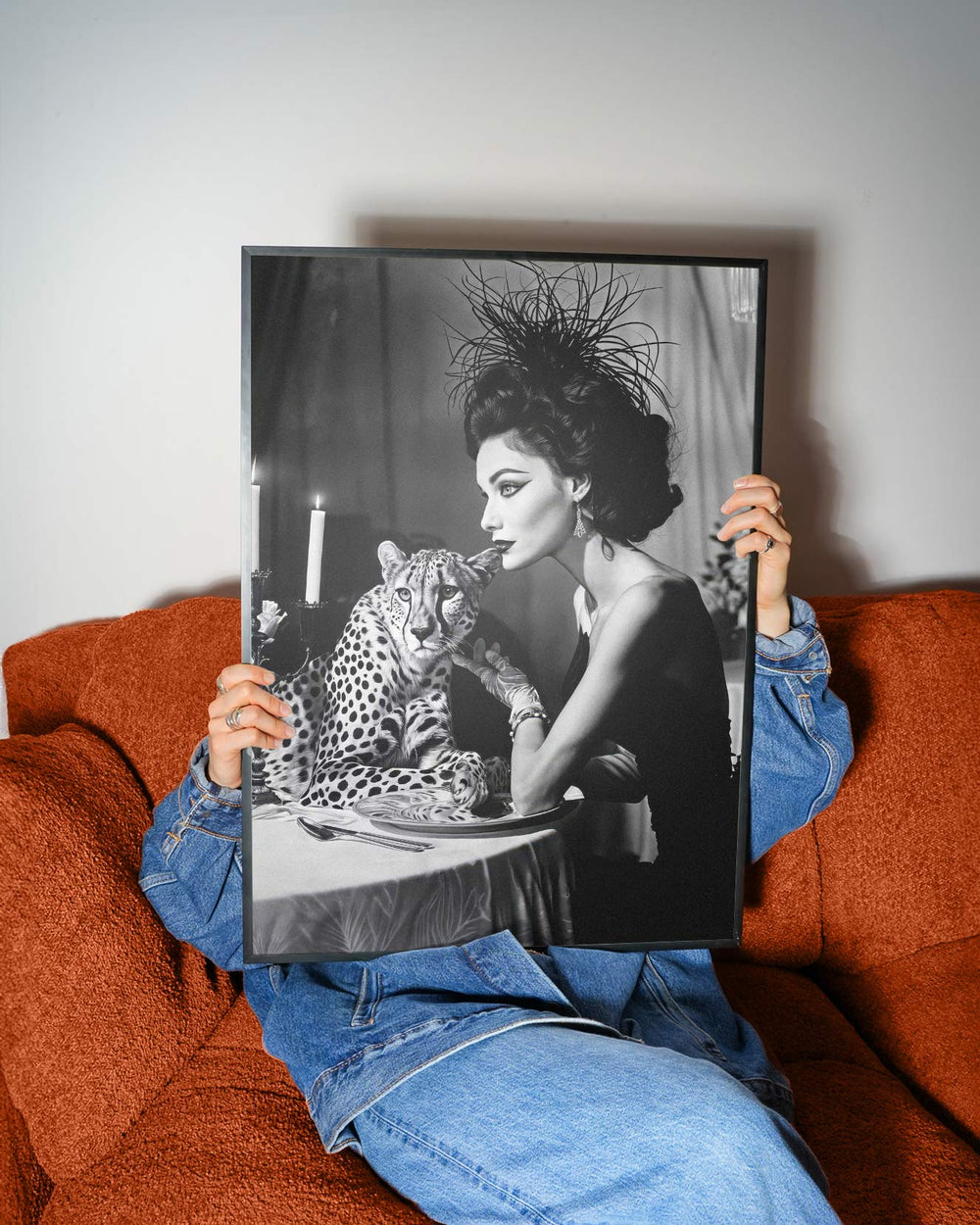 Person holding a black and white photograph of a woman with a leopard on a table.