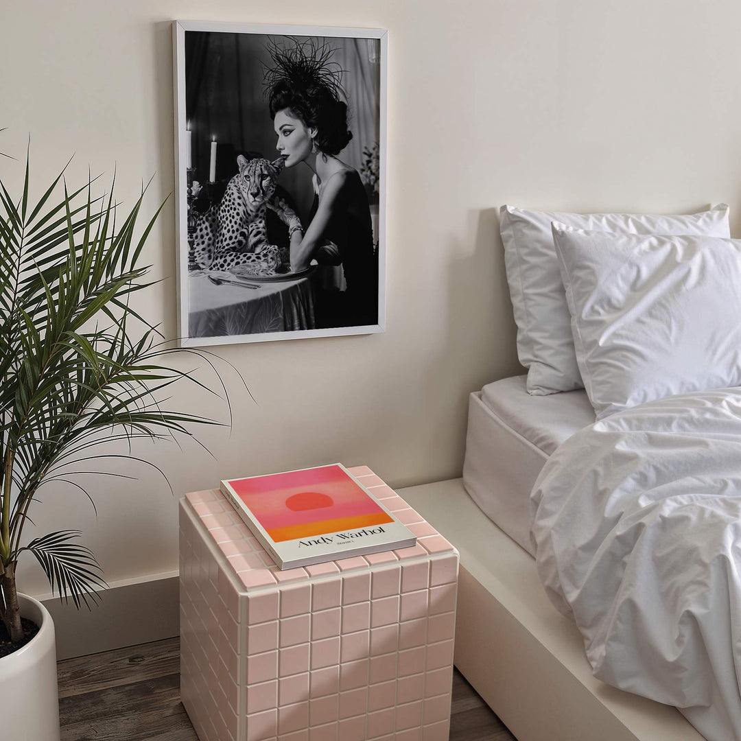 Modern bedroom with a bed, side table, and picture on the wall.