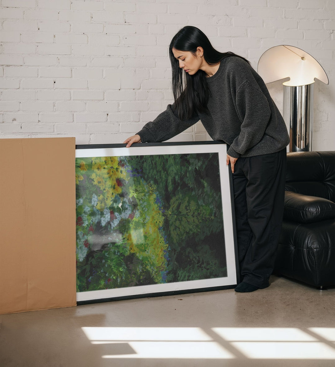 Woman holding a painting in a living room.