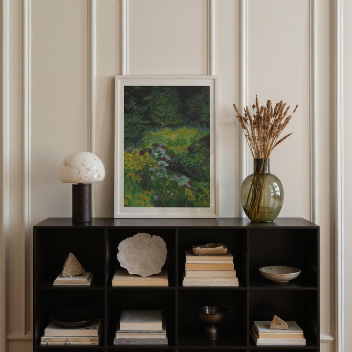 Decorative shelf with books, a vase, and a painting against a paneled wall.