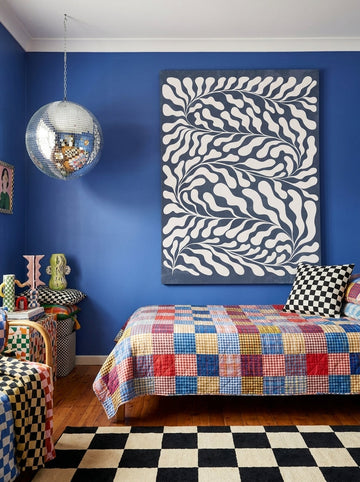 Stretched canvas wall art styled on the wall in a colourful eclectic bedroom
