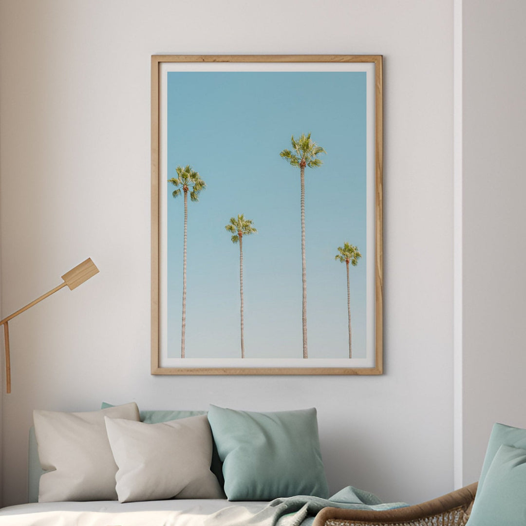 a photo of four palm trees on the wall in a coastal living room