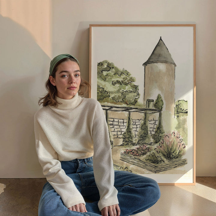 Woman sitting in front of watercolor painting of a tower and garden.