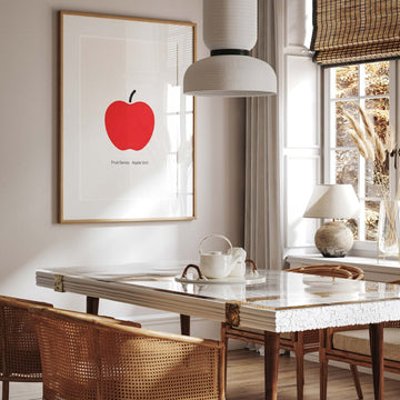 Dining room with marble table, wicker chairs, and artwork of a red apple.