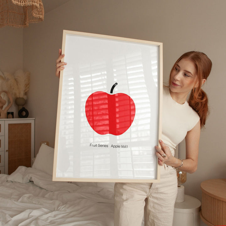 Woman holding a artwork of a red apple with a white background