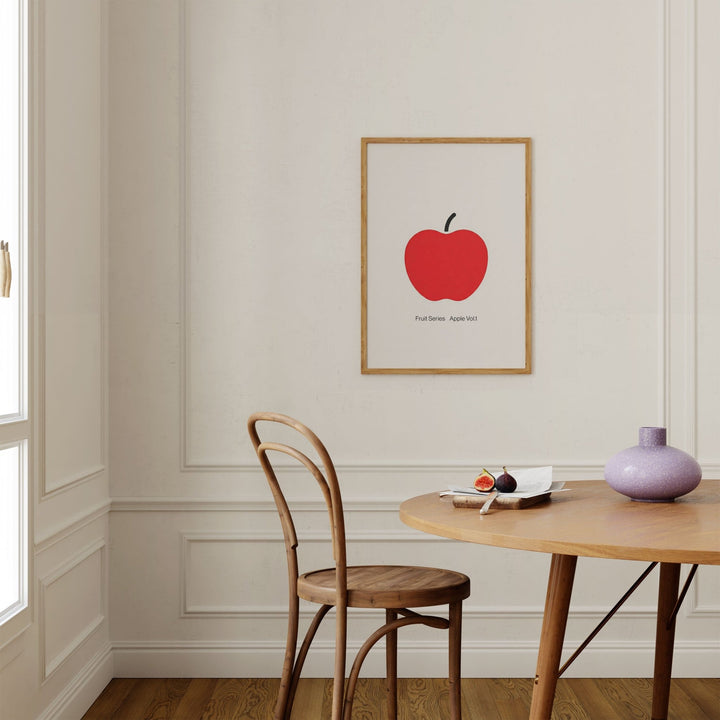 Dining room with a wooden chair, table, and red apple print on the wall.