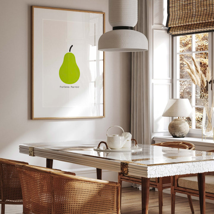 Dining room with a marble table, wicker chairs, and a picture of a green pear on the wall.