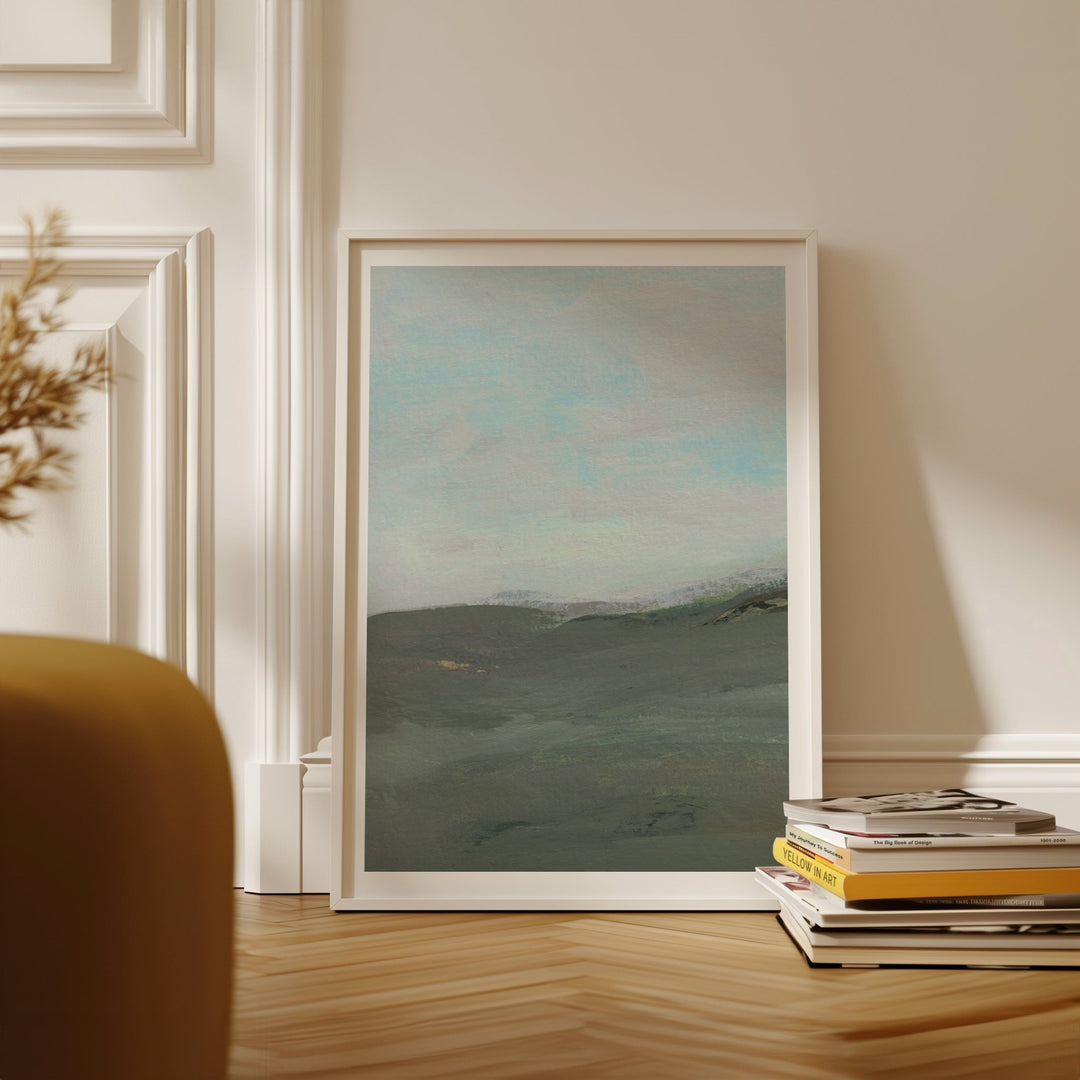 Landscape painting on a wall with books stacked below