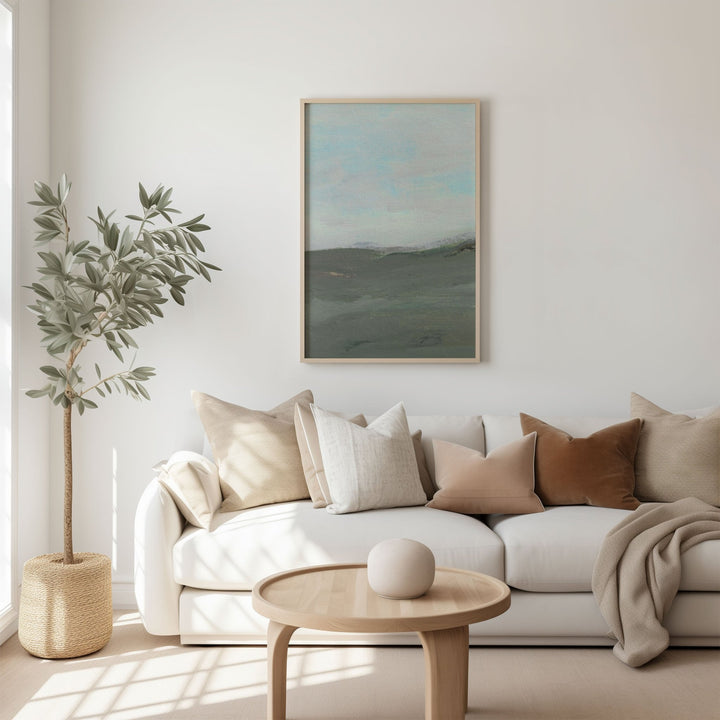 Modern living room with a white sofa, wooden coffee table, and artwork on the wall.