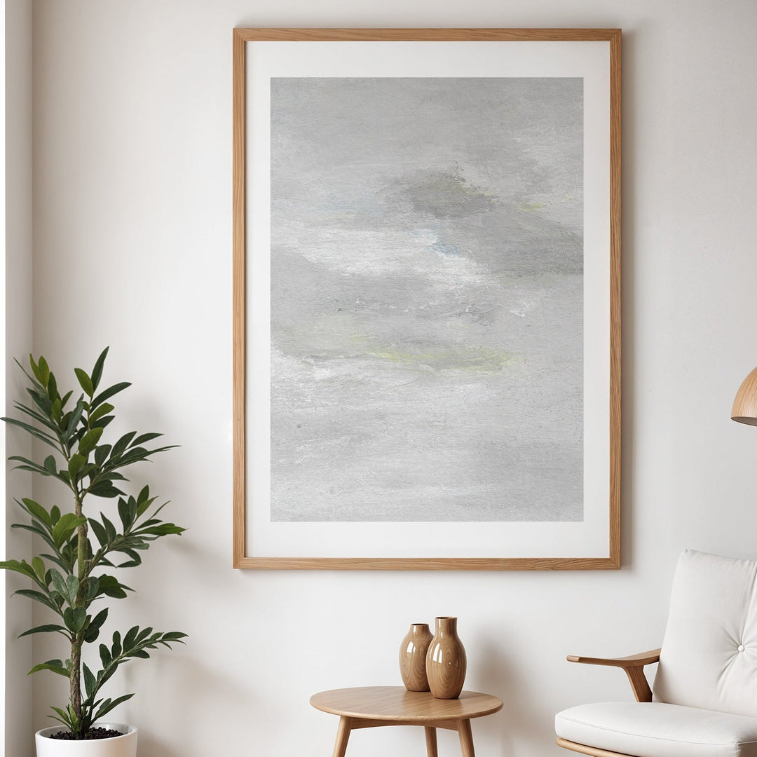 Abstract art piece on a wall in a living room setting with a plant and table.