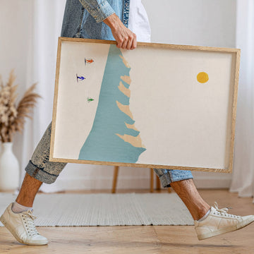 person walking holding an artwork of skiers