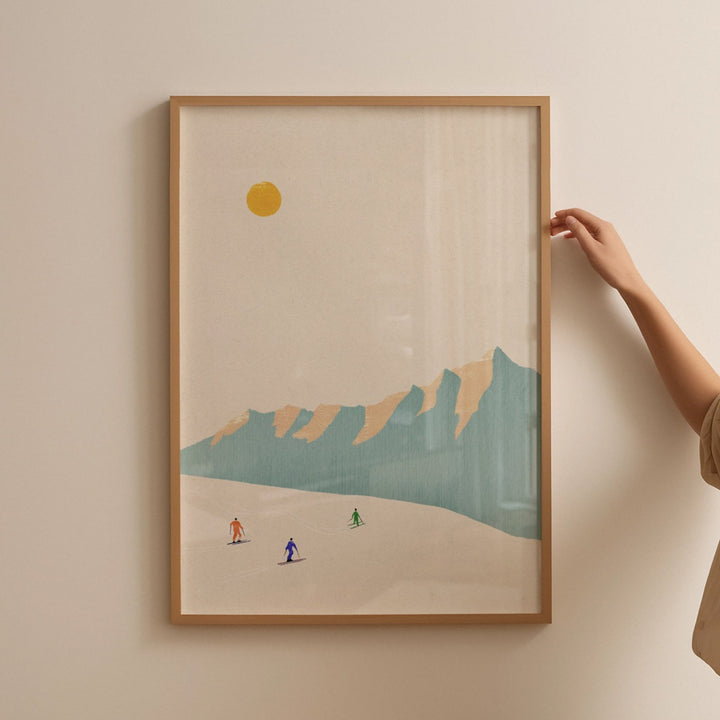  a hand holding an artwork of skiers hanged on wall