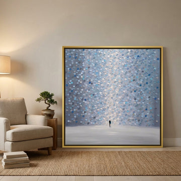 Oversized statement canvas wall art with a gold leaf surround leaning against the wall in a warm Japandi living room