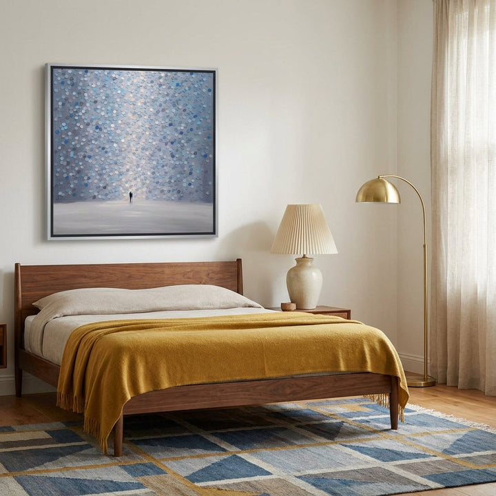 Canvas wall art with a silver leaf surround styled on the wall in a mid-century bedroom