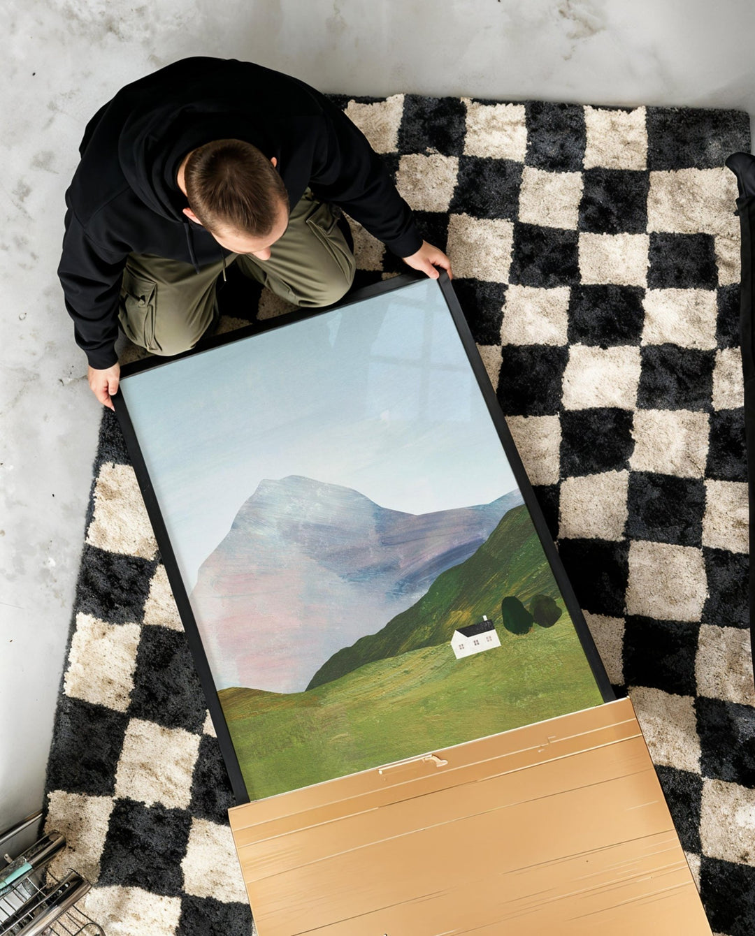 artwork of landscaped being unboxed on checked rug