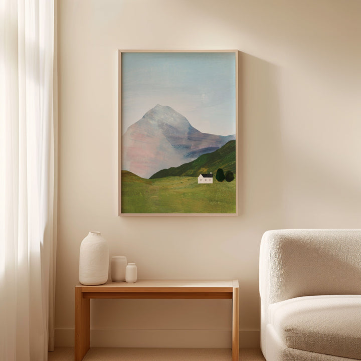 landscape painting on a wall above a wooden side table with decorative items and a beige armchair.