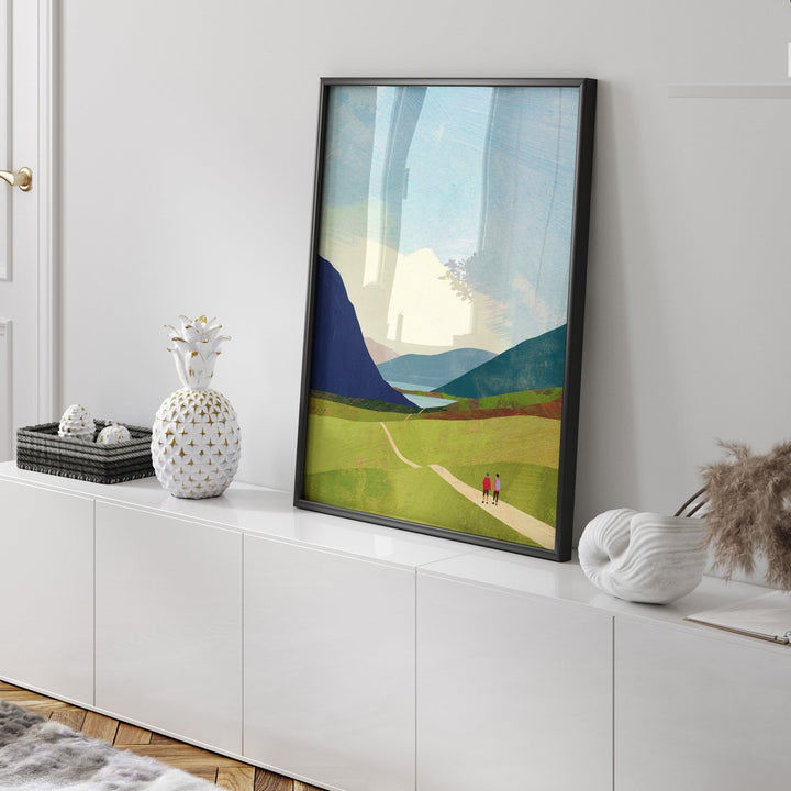 Artwork of a landscape with mountains and a path on a white wall.